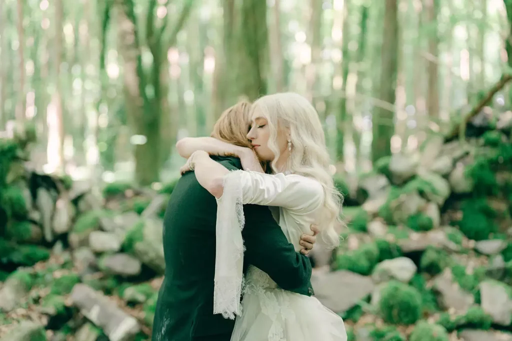 Destination wedding at Ashford Castle, County Mayo — bride and groom embracing among moss-covered stones in a forest portrait on the estate grounds.