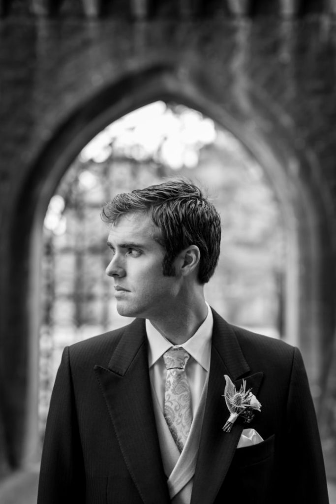 Destination wedding morning portrait at Ashford Castle, County Mayo — groom standing outdoors on the castle estate grounds during a morning portrait session on the wedding day.