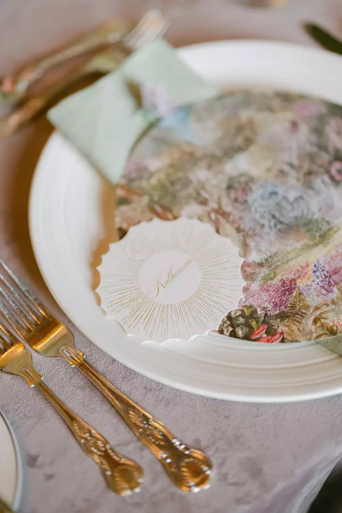 Destination wedding ceremony at Ashford Castle, County Mayo — colourful wedding stationery with a name card placed on a napkin within a reception place setting.