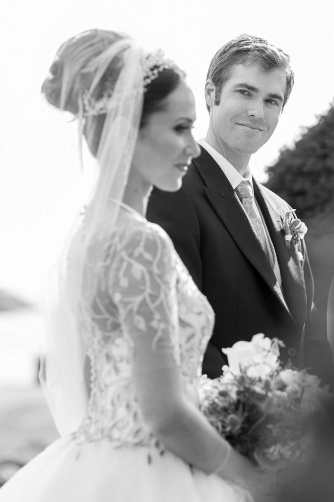 Destination wedding ceremony at Ashford Castle, County Mayo — bride and groom standing together during the ceremony as the groom looks towards the bride.