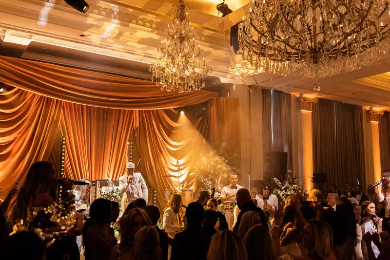 Irish destination wedding at Adare Manor, County Limerick — wedding reception with live band performing on stage as guests dance on the dance floor.