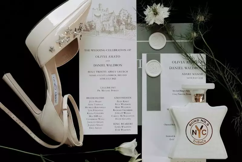Irish destination wedding at Adare Manor, County Limerick — flat lay of wedding day stationery, bridal shoes and perfume arranged for a detail photograph.